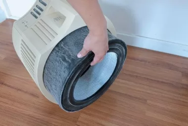 Air purifier maintenance. The dirty filter of air purifier. Filter replacement. - a person cleaning